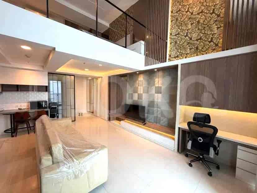 Area tamu bergaya loteng modern dengan sofa besar, set makan, dan dapur terintegrasi.