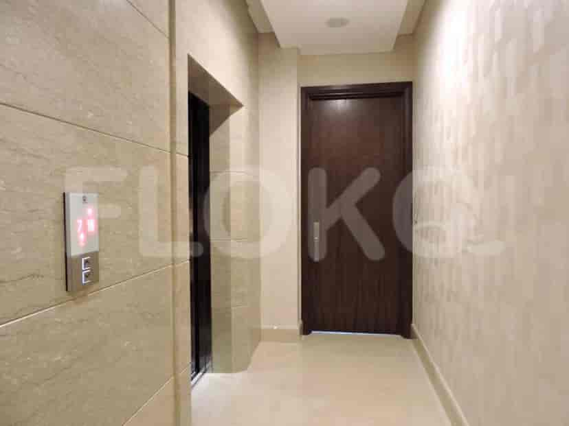 Lorong bergaya hotel dengan lift, pintu kayu, dan dinding berubin marmer.