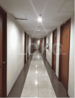 A long hallway with multiple doors leading to rooms.