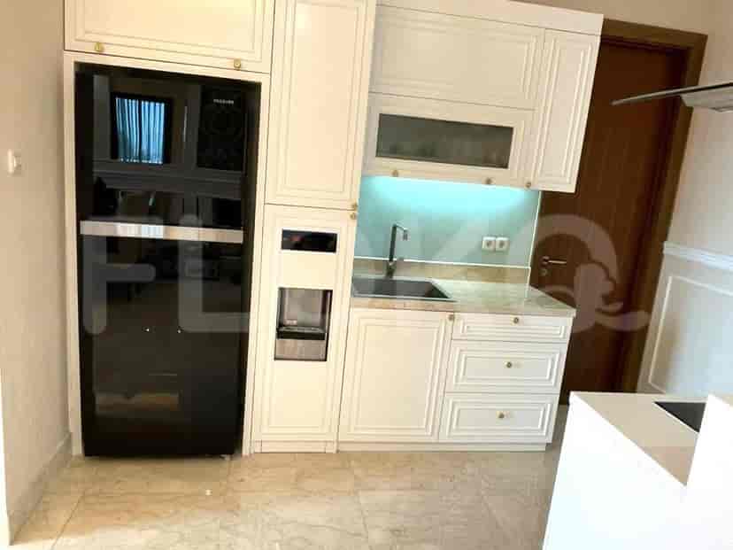 A modern kitchen with white cabinetry, a black refrigerator, built-in water dispenser, sink, and marble countertops.