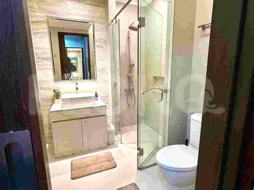 Bathroom with a toilet, glass-enclosed shower, and vanity.