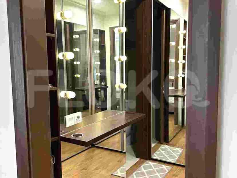Dressing area with a vanity table, mirrors, and integrated lighting.