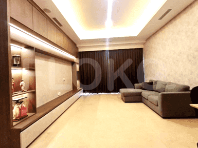 A modern living room with a built-in entertainment unit, L-shaped sofa, and large windows.