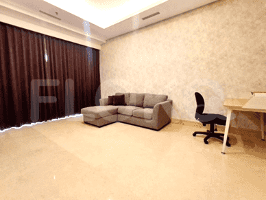 Living room with an L-shaped sofa, work desk and a large window with curtains.