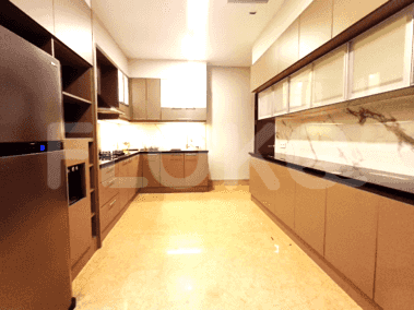 Modern kitchen with wooden cabinets and a stainless steel refrigerator.