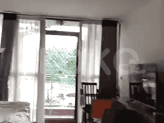 Living room with balcony access and curtains.