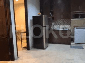 A kitchen with a refrigerator, cabinets, and a sink.