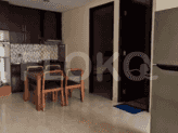 A kitchen and dining area with wooden furniture, a refrigerator, and a glimpse of the bathroom.