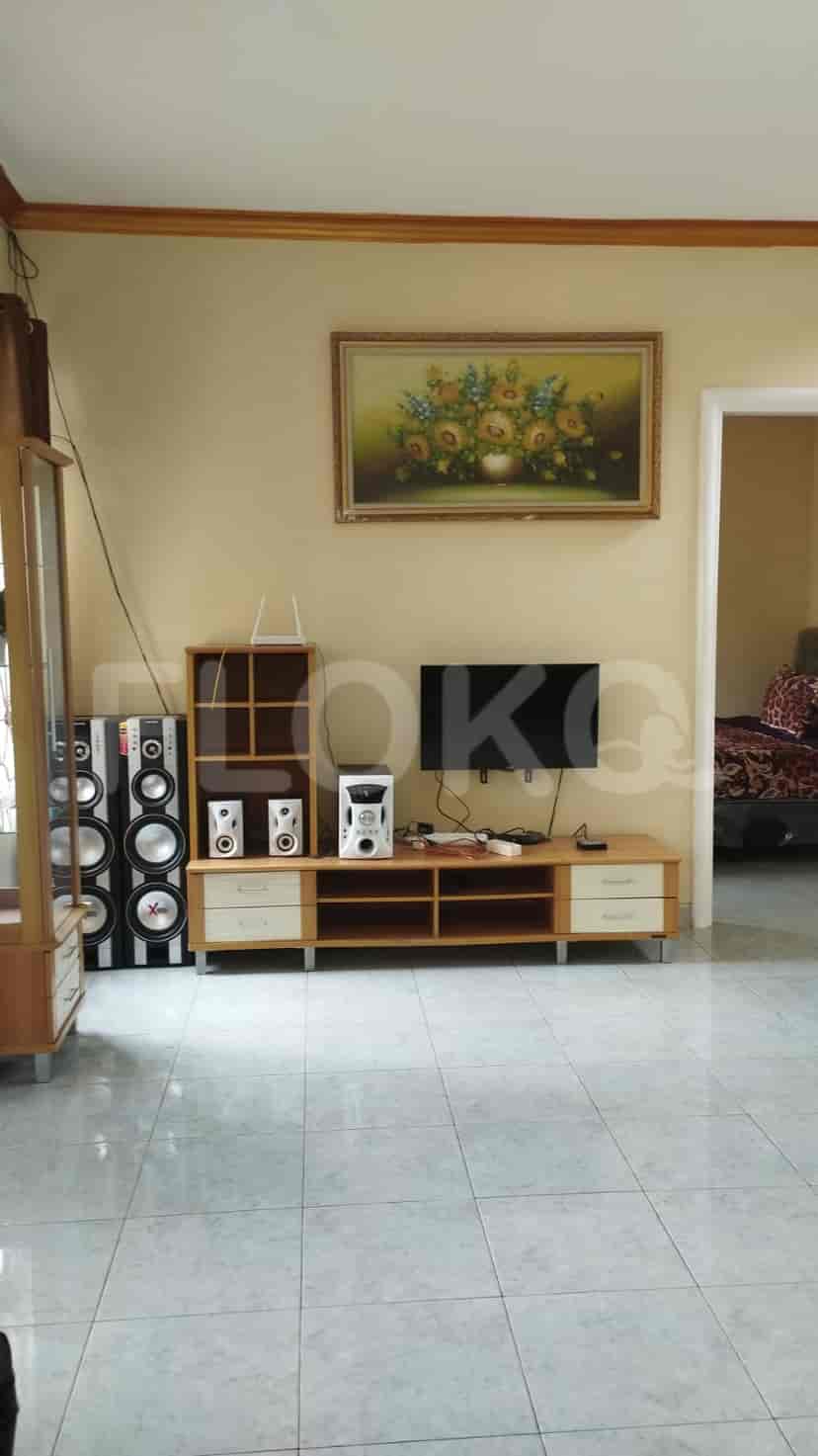 A living room with brown leather furniture, a wooden coffee table, and window curtains.