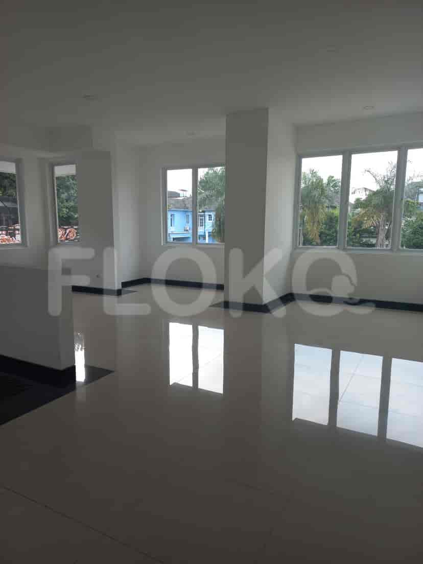 Another view of the living area with large windows and white walls, emphasizing the open space.