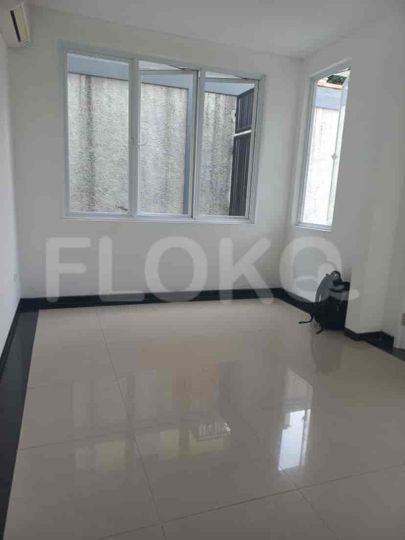 A small room with a window and tiled flooring.