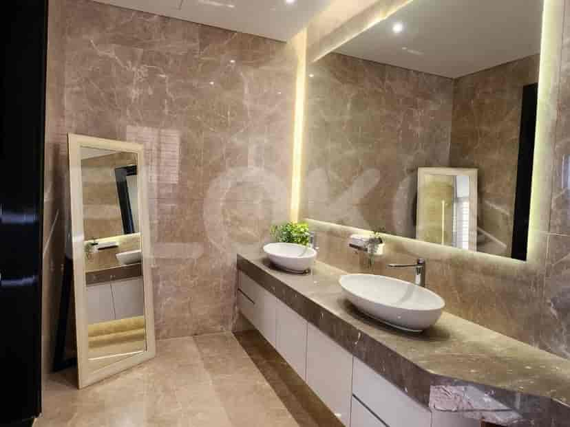 A modern bathroom with marble walls, a large mirror, and a double sink vanity.
