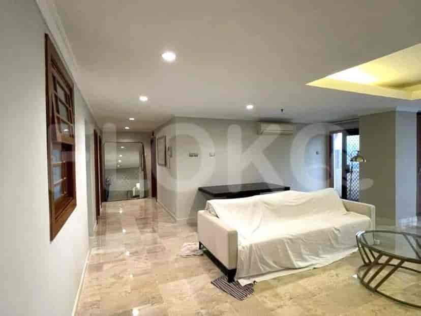 A spacious living room with a sofa, hardwood flooring, and a view of the entry.