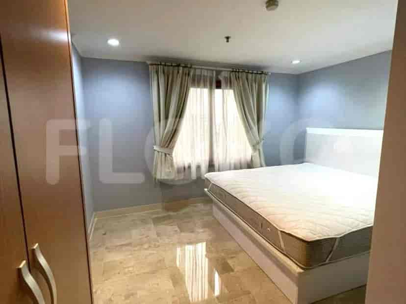 A bright bedroom with a double bed and light blue walls.