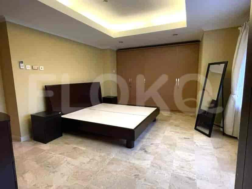 A bedroom featuring a dark wooden bed, a side table, and a large closet.