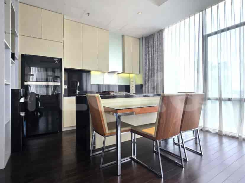 Dapur modern dengan meja dapur gelap, lemari terang, dan meja makan.