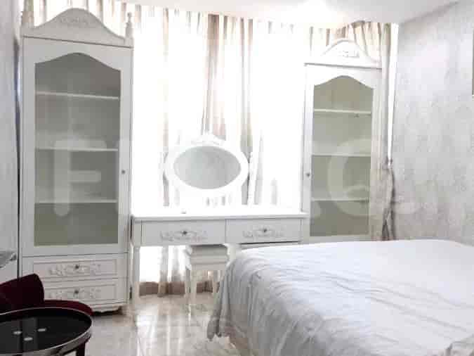 A bedroom with two cabinets, a vanity table, and a bed.