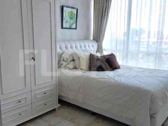A bedroom with a bed, a wardrobe, and a window.