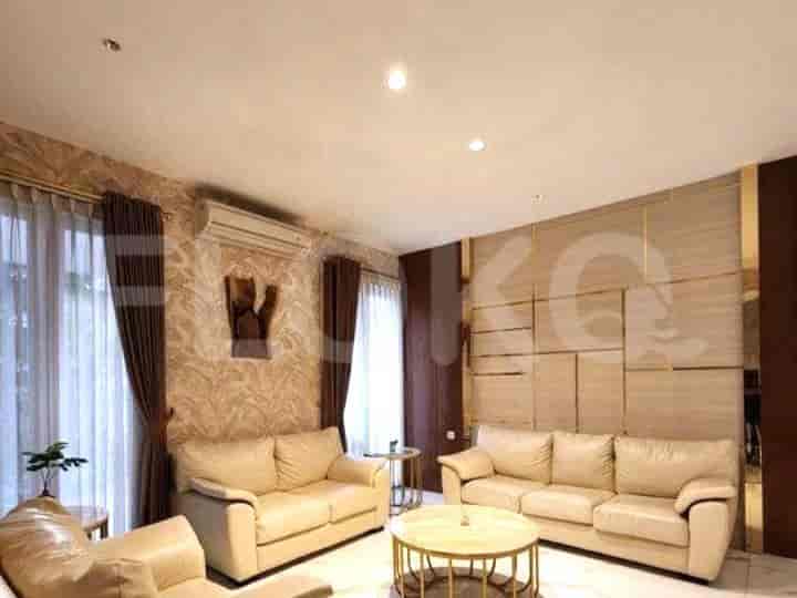 A living room with cream-colored sofas, a round coffee table, and a feature wall.