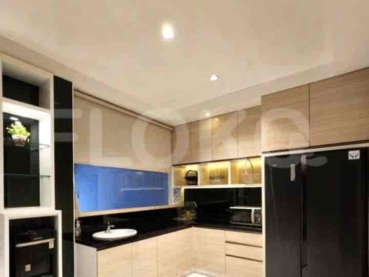 A modern kitchen with wooden cabinets, black countertops, and a black refrigerator.