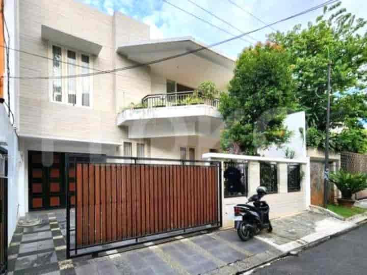 The exterior of a two-story modern house with a wooden gate, balcony, and a parked scooter.
