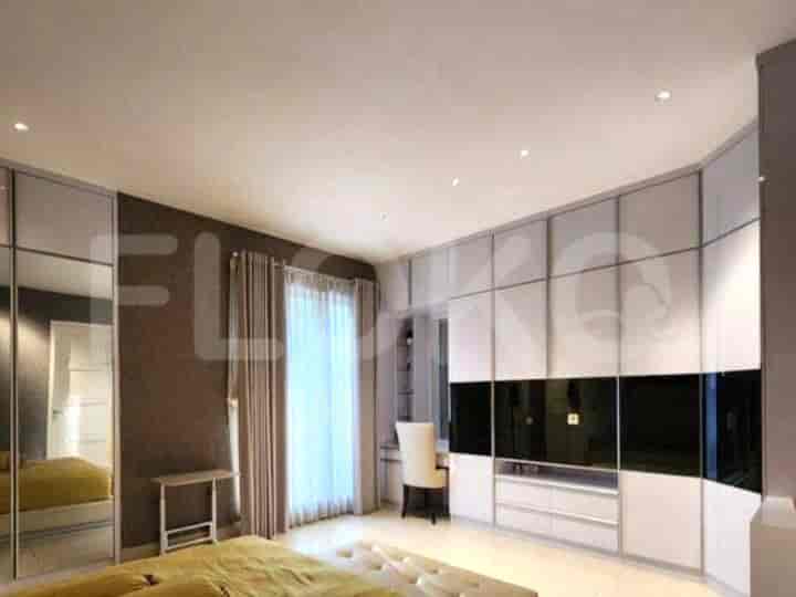 A bedroom with a large wardrobe, a bed, and a desk.