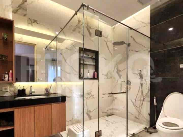 A modern bathroom with a glass-enclosed shower, a vanity, and a toilet.