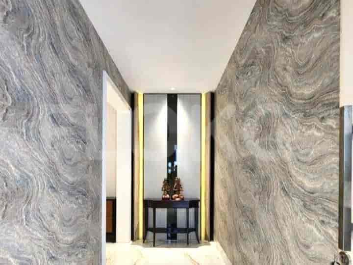 A hallway with marble walls and a console table.