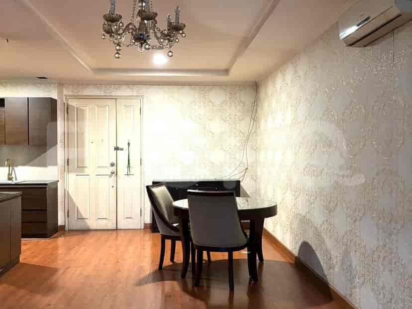 A dining area with a round table and a chandelier.
