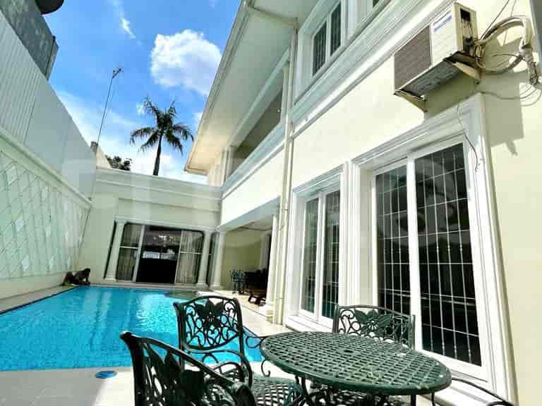 Backyard view with a swimming pool, outdoor seating, and a palm tree.