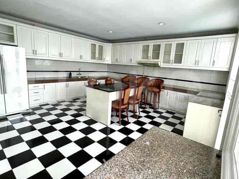 Kitchen with white cabinets, black and white checkered flooring, and a granite countertop island.