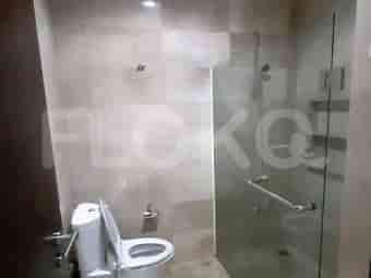 A modern bathroom with a glass shower and a simple white toilet.