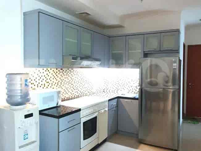 A modern kitchen with light blue cabinets, a refrigerator, and a microwave.