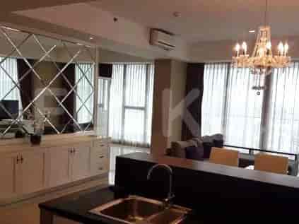 An interior with a dining table, mirror wall, and chandelier.