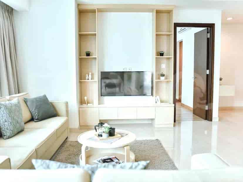 A living room scene showing a light-colored sofa, media cabinet, and a TV.