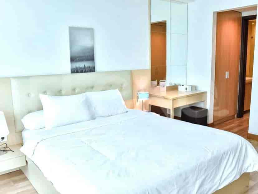 Bedroom with a bed, large mirror, and a desk area.
