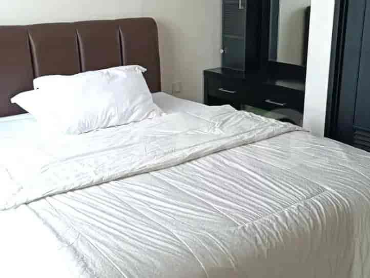 A bedroom with a bed featuring a large headboard