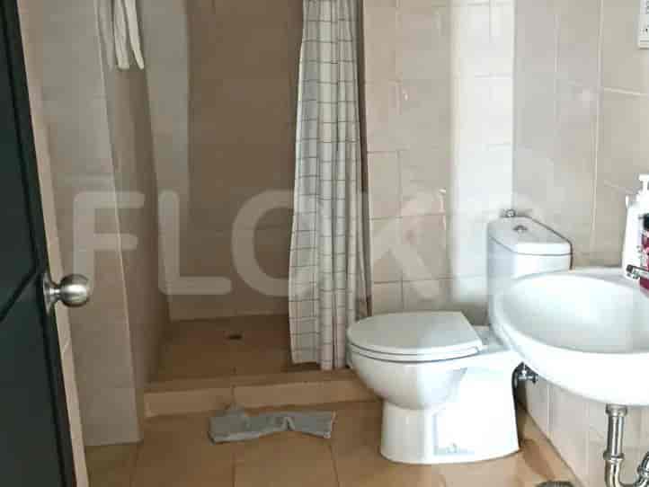 A bathroom featuring a shower area and a toilet.