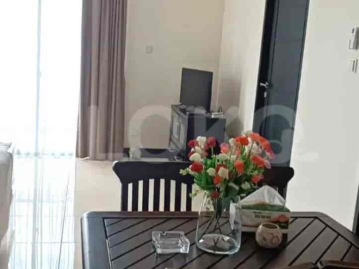 Dining table and flowers with a TV in the background
