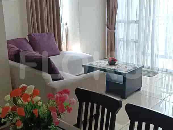 Another view of the living room showcasing the L-shaped sofa, and a glass table.