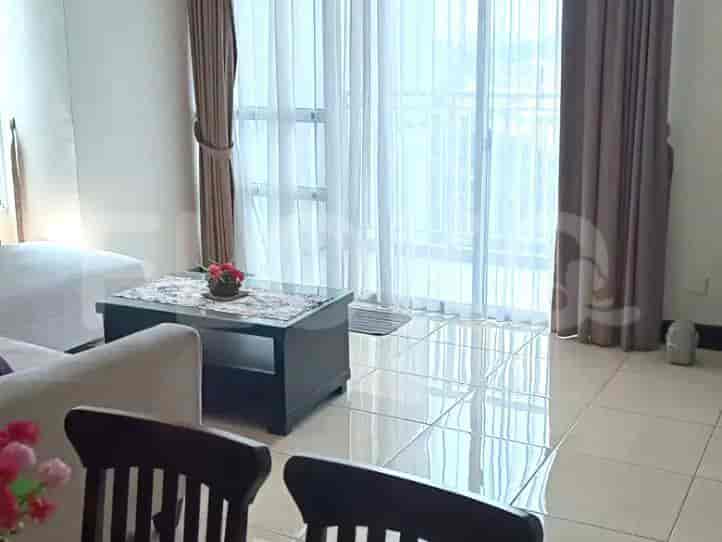 The living room area showing the sofa and a table in front of the window.