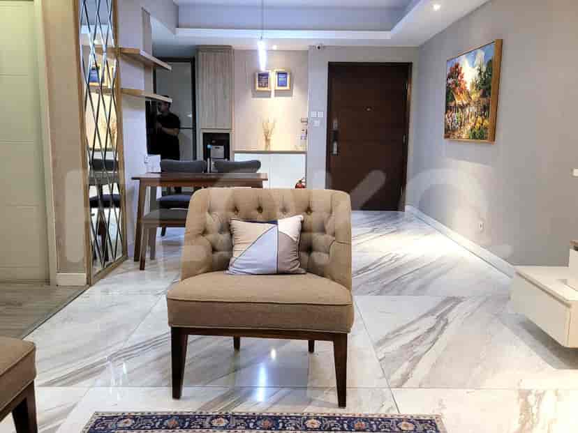 A combined living and dining area with a sofa, chair, dining table, and artwork.