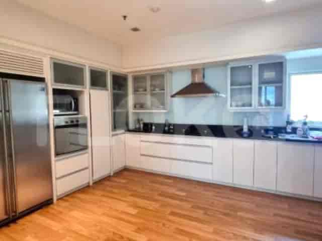 A modern kitchen with white cabinets, a large refrigerator, and stainless steel appliances.