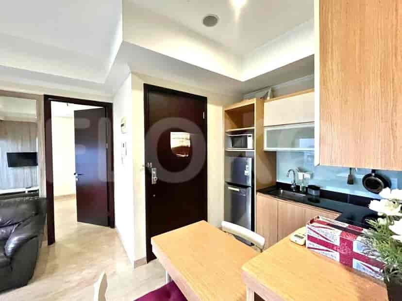Dapur dengan meja makan, lemari, dan akses ke ruangan lain.