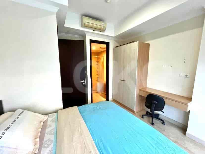 Kamar tidur dengan tempat tidur, lemari, meja, dan pemandangan kota.