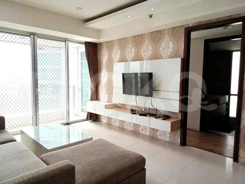 Modern living room with L-shaped sofa, TV, and balcony access.