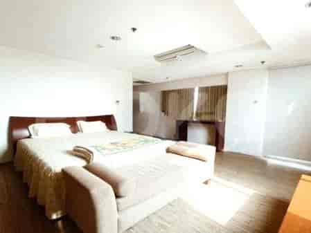 Kamar tidur dengan tempat tidur dan meja samping tempat tidur.