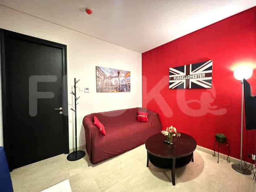 A living room featuring a red sofa, a round table, and a London-themed decor.