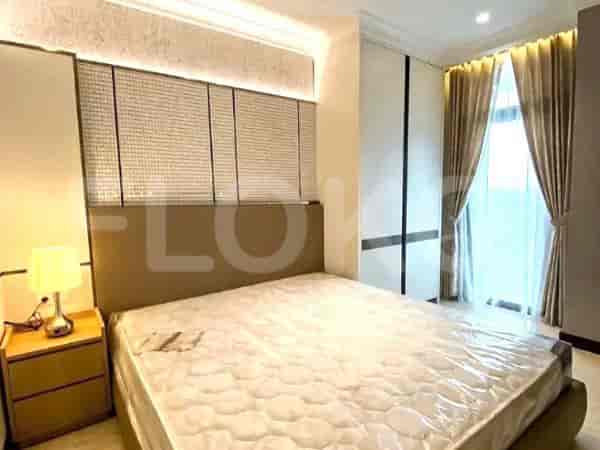 A well-lit bedroom with a large bed, bedside table, and stylish headboard.