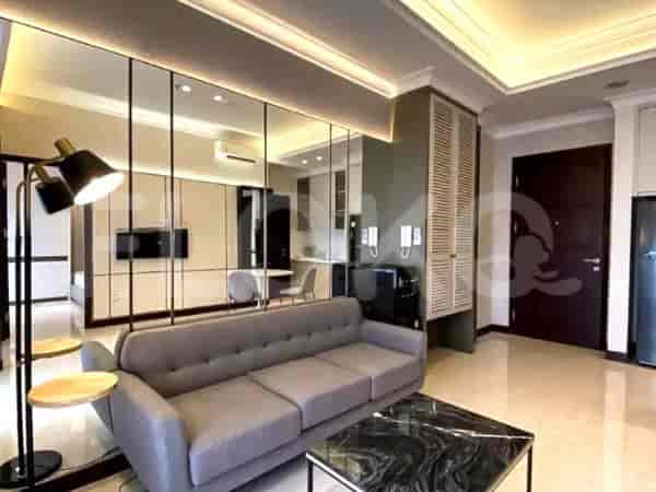 A modern living room featuring a gray sofa, a coffee table, and mirrored wall accents.